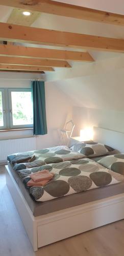 ein großes Bett in einem Zimmer mit einer Decke in der Unterkunft Fliederhaus Dresden in Dresden