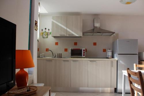 eine Küche mit einem weißen Kühlschrank und einer Mikrowelle in der Unterkunft Casa Mirna in Rio nellʼElba