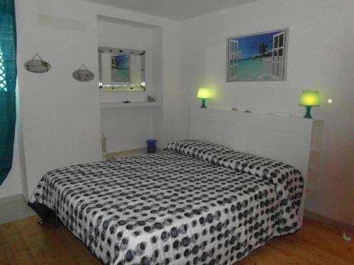 ein Schlafzimmer mit einer schwarzen und weißen Bettdecke auf einem Bett in der Unterkunft Casa Mirna in Rio nellʼElba