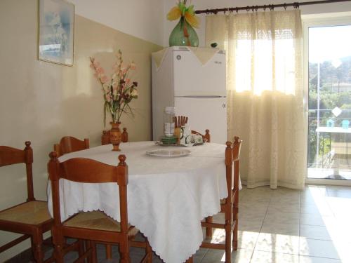 a kitchen with a table and a white refrigerator at George's Apartments in Chrani