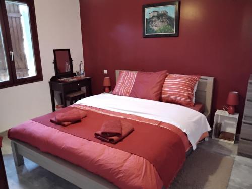 a bedroom with a large bed with red walls at Le violet in Gaillac