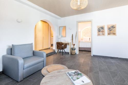 a living room with a chair and a table at Bay View Suites in Ayios Nikolaos Sithonia