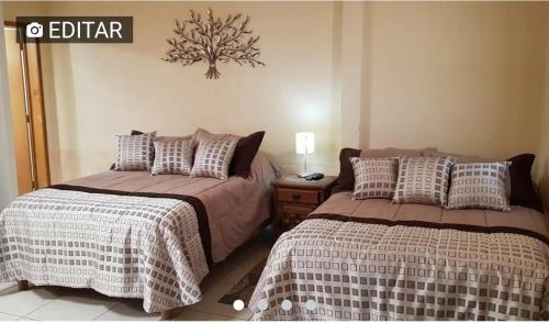 two beds sitting next to each other in a bedroom at Suites Pozos Mágico in San Luis de la Paz