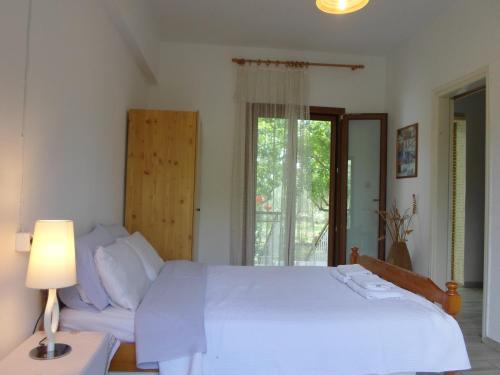 a bedroom with a white bed and a couch at Bozelia Apartments in Toroni