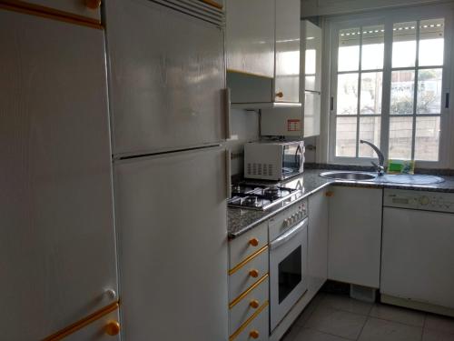 uma cozinha com um frigorífico e um fogão forno superior em Apartamentos Sanxenxo Progreso 140 em Sanxenxo