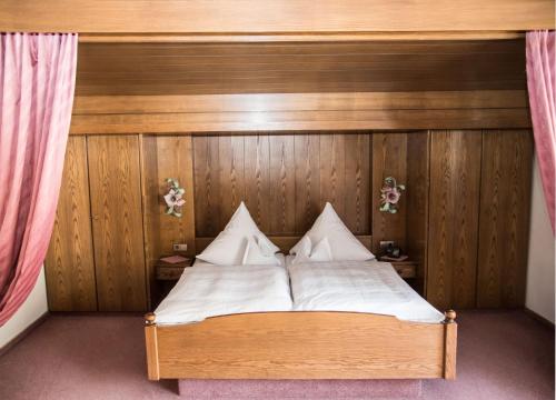 a bed with white sheets and pillows in a room at Haus Feichtner in Reit im Winkl