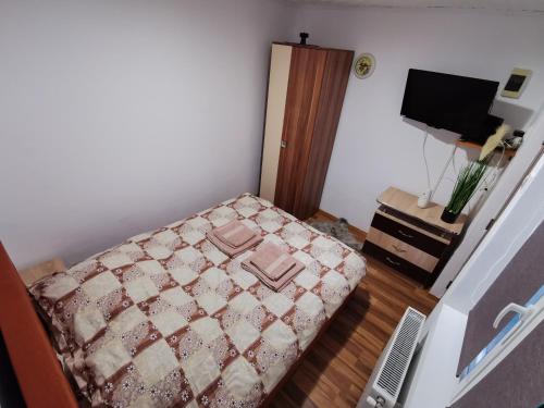a small bedroom with a bed and a television at Apartament Dilama Sinaia in Sinaia