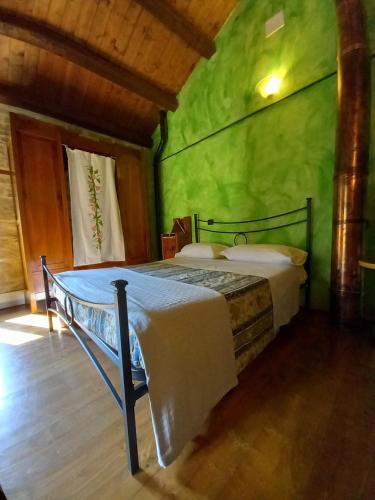 a bedroom with a bed in a green room at CASINA LA QUERCIA in Santa Sofia