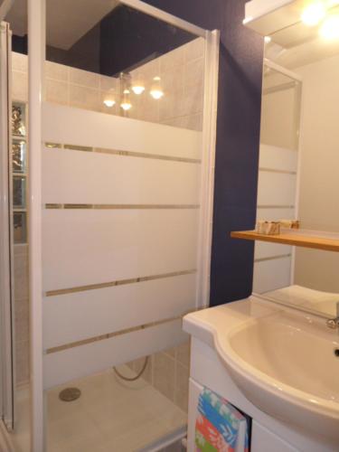 ein weißes Badezimmer mit einem Waschbecken und einem Spiegel in der Unterkunft logement entre mer et montagne in Roujan
