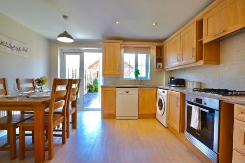 una cucina con armadi in legno, un tavolo e una sala da pranzo di Felton House a Stafford