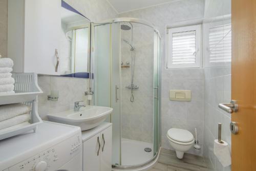 La salle de bains est pourvue d'une douche, de toilettes et d'un lavabo. dans l'établissement Skoro Residence, à Vinišće