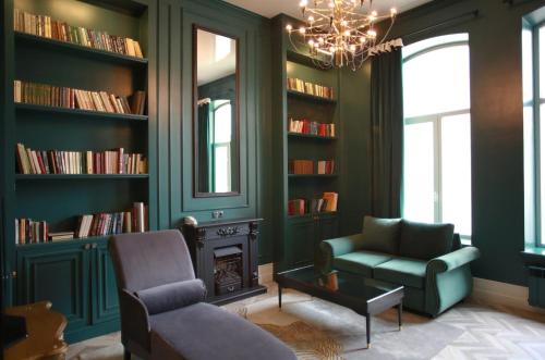 a living room with green walls and a chandelier at Bonhotel in Astrakhan