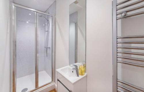 a white bathroom with a shower and a sink at Henry Court Apartment 1 in York