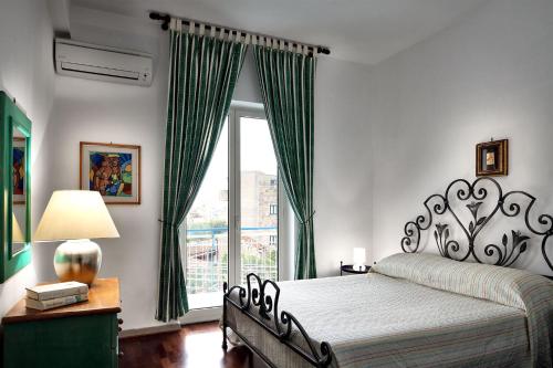 Un dormitorio con una cama y una ventana grande. en Caruso 1 by Villasandco RentalSorrento, en Sorrento