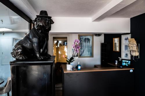 a statue of a man sitting on top of a table at Hôtel et Appartement "Le Maguy" in Cassis