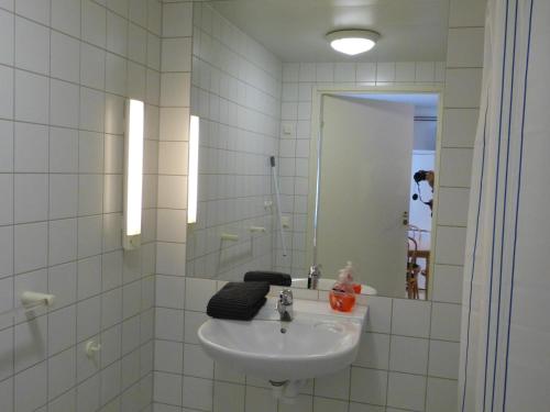 un bagno bianco con lavandino e specchio di Sangis Motell och Camping a Sangis