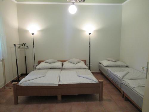two beds in a room with lights on the wall at Aranyalma Vendégház in Gárdony