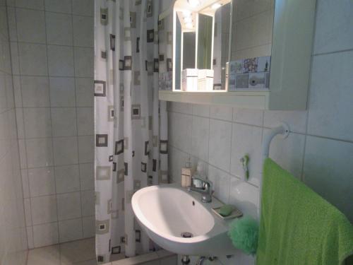 a white bathroom with a sink and a mirror at Aranyalma Vendégház in Gárdony