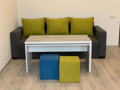 a couch with a coffee table and two cushions at Hotel Menua in Yerevan