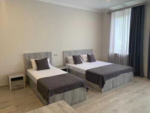 a hotel room with two beds and a window at Hotel Menua in Yerevan