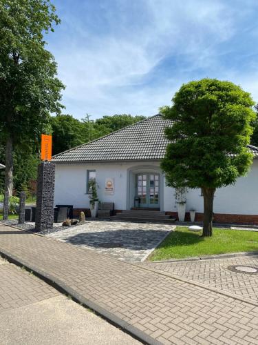 a white building with a tree in front of it at Ho(s)tel Ahrbergen in Giesen