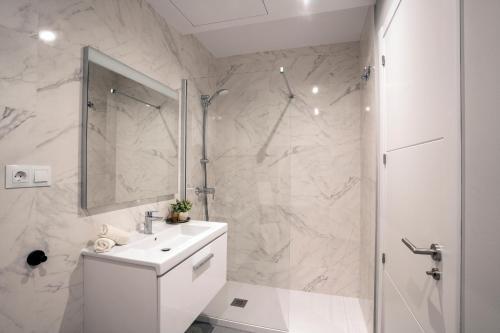 a white bathroom with a sink and a shower at Sealine luxury apartment in Torrox Costa in Torrox Costa