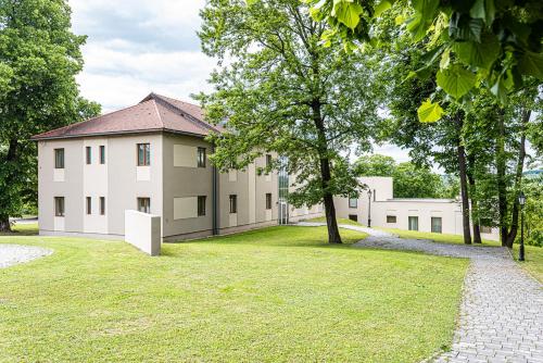 a large building with a grassy yard in front of it at La Contessa Castle Hotel in Szilvásvárad
