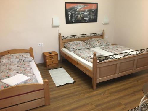 1 dormitorio con 2 camas y mesa en Szieszta Vendégház, en Sárospatak