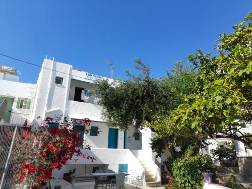 a white building with red flowers in front of it at Avra Studios in Masouri