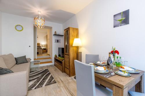 a dining room and living room with a table and chairs at Maximilian&Stela in Poreč