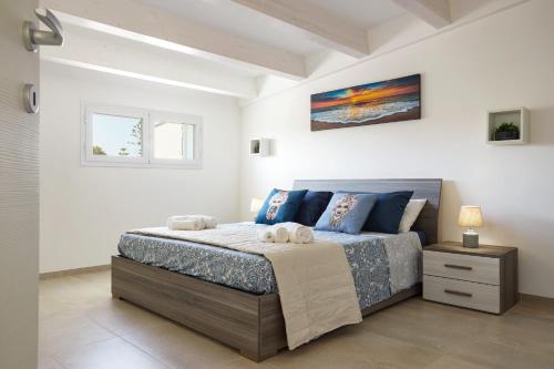 a bedroom with a bed with two towels on it at Villa Ulivo - IsulaTravel in Marzamemi