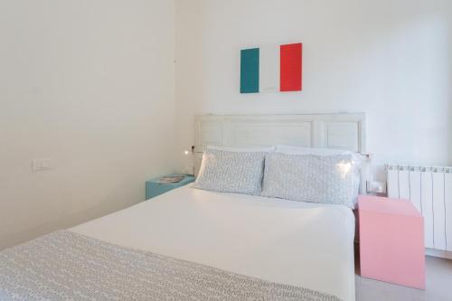 a bedroom with a white bed and a painting on the wall at La Casa dell'Architetto by Rent All Como in Blevio