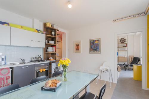 a kitchen with a table with a vase of flowers at La Casa dell'Architetto by Rent All Como in Blevio