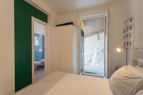 a bedroom with a white bed and a green wall at La Casa dell'Architetto by Rent All Como in Blevio
