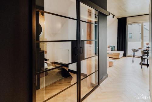 a room with glass doors and a living room at Apartament LUX 2 Cieplice in Jelenia Góra
