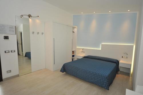 a bedroom with a blue bed and a mirror at Casa Campanella Resort in Capoliveri