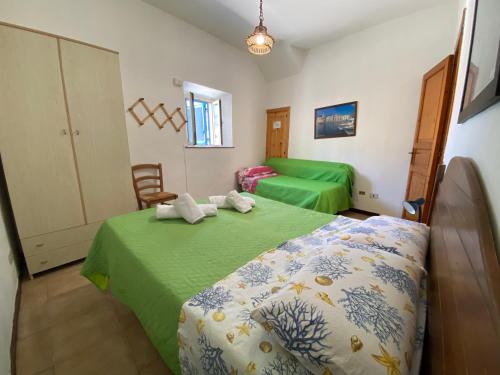 una camera con due letti con lenzuola verdi di Lipari Centro Storico Flat 7 mins from port a Città di Lipari