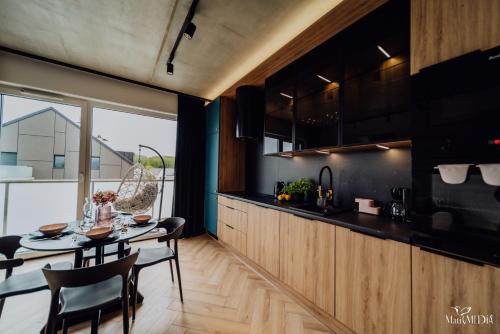 a kitchen with a table and chairs in a room at Apartament LUX 2 Cieplice in Jelenia Góra