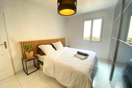 勒博塞VILLA 6 PERSONNES /PISCINE/CAMPAGNE/TERRAIN DE PETANQUE/15 km BANDOL的一间卧室，有一张白色的床和一扇窗户