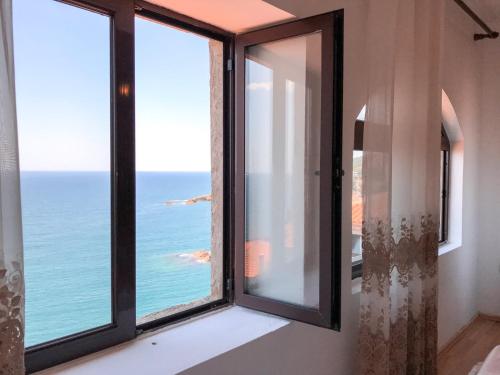 a room with a window with a view of the ocean at Guest house Naser in Ulcinj