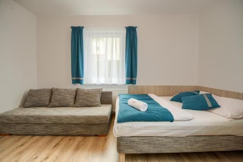 a bedroom with a bed and a couch at Purtulka pokoje klimatyzowane in Pobierowo