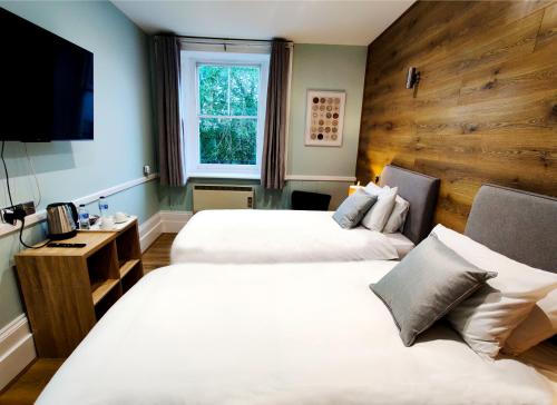 Habitación de hotel con 2 camas y TV en The Swan Hotel, en Hythe