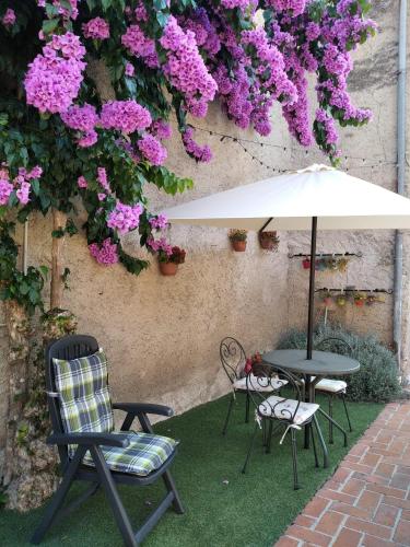 tavolo e sedie con ombrellone e fiori di Il Giardino di Laura a Toscolano Maderno