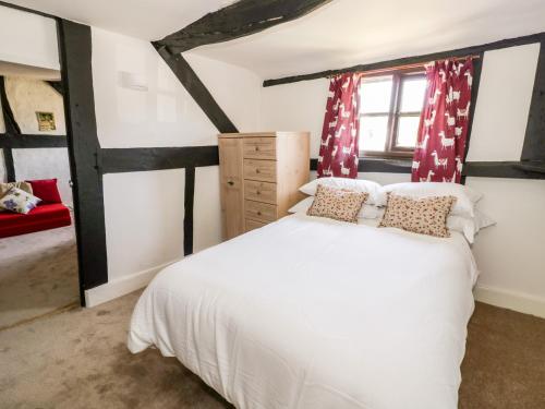 a bedroom with a white bed and a window at Mainstone House in Ledbury