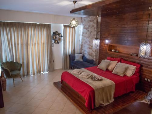 スパルティにあるLycurgus - The Spartan Homeのベッドルーム(赤い大型ベッド1台、椅子付)