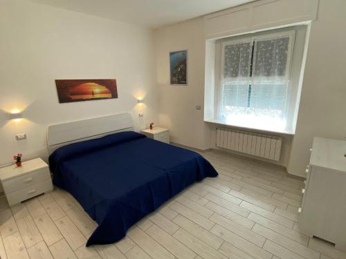 a bedroom with a blue bed and two windows at Canada in Stresa