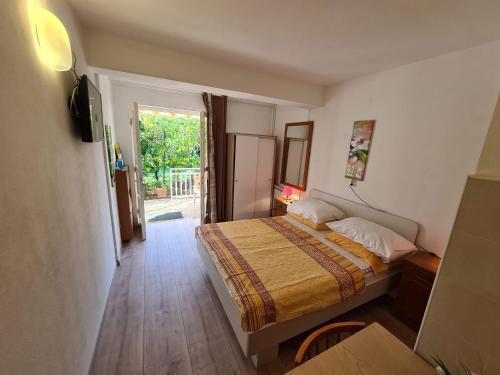 a small bedroom with a bed and a sliding glass door at Apartments Ana in Medulin