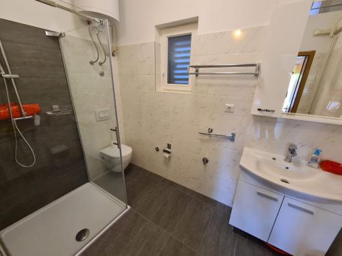 a bathroom with a shower and a sink and a toilet at Apartments Ana in Medulin