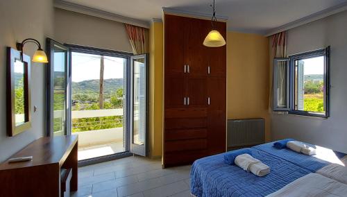 ein Schlafzimmer mit Bett, Schreibtisch und Fenstern in der Unterkunft Thealia in Karefilianá