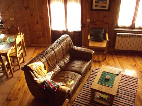a living room with a leather couch and a table at Artesano II in Navarredonda de Gredos